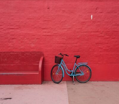 Blue bicycle agains red wall