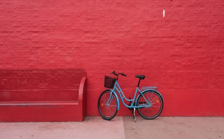 Blue bicycle agains red wall